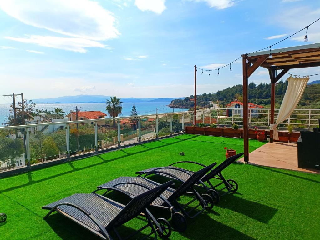 a group of chairs sitting on top of a lawn at Salonikiou Beach Apartments in Agios Nikolaos