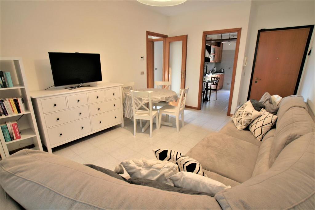 un soggiorno con divano e TV di Appartamento - PUNTA SABBIONI a Cavallino-Treporti