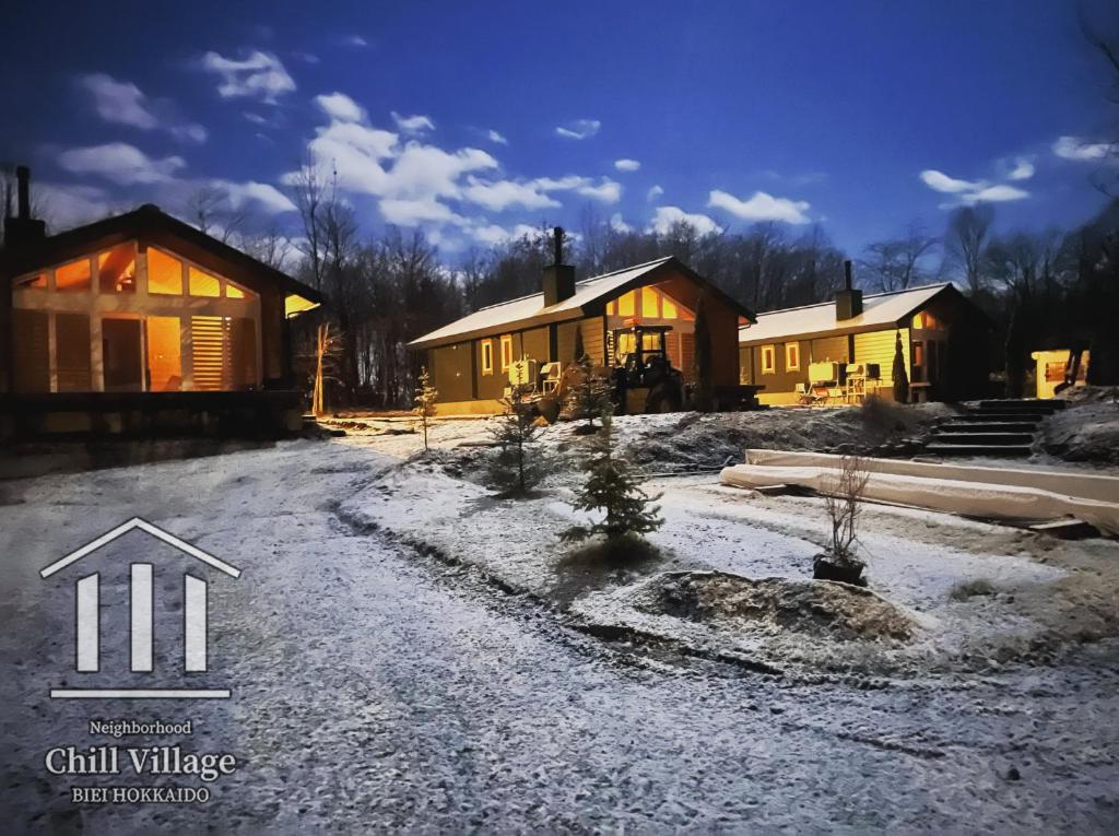 a house with snow on the ground in front of it at Chill Village in Biei