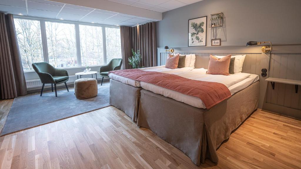 a hotel room with a large bed and chairs at Lundsbrunn Resort & Spa in Lundsbrunn