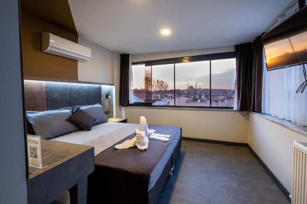 a bedroom with a bed and a large window at The Queen Hotel in Istanbul