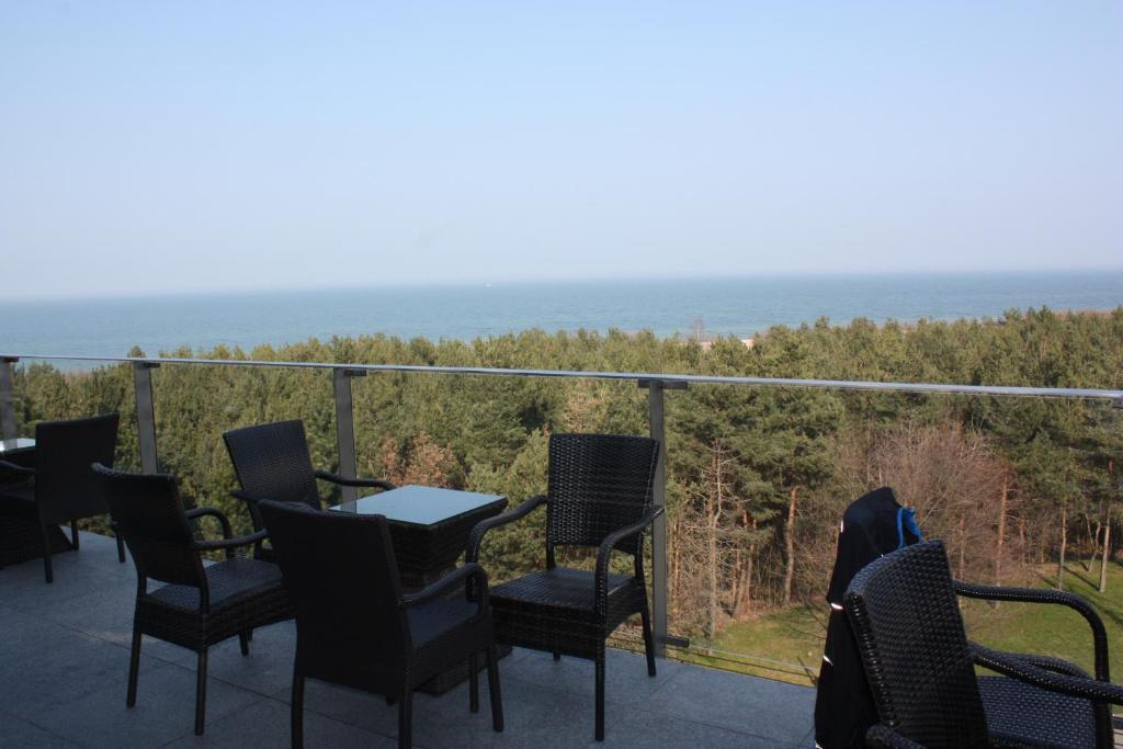 a balcony with chairs and a table and the ocean at Apartament Patio 50 m od plaży in Władysławowo