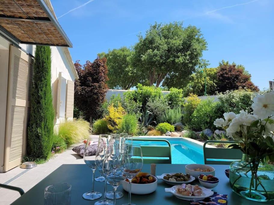 una mesa con copas de vino y comida en el patio en Magnifique Villa avec Piscine en Provence, en Verquières