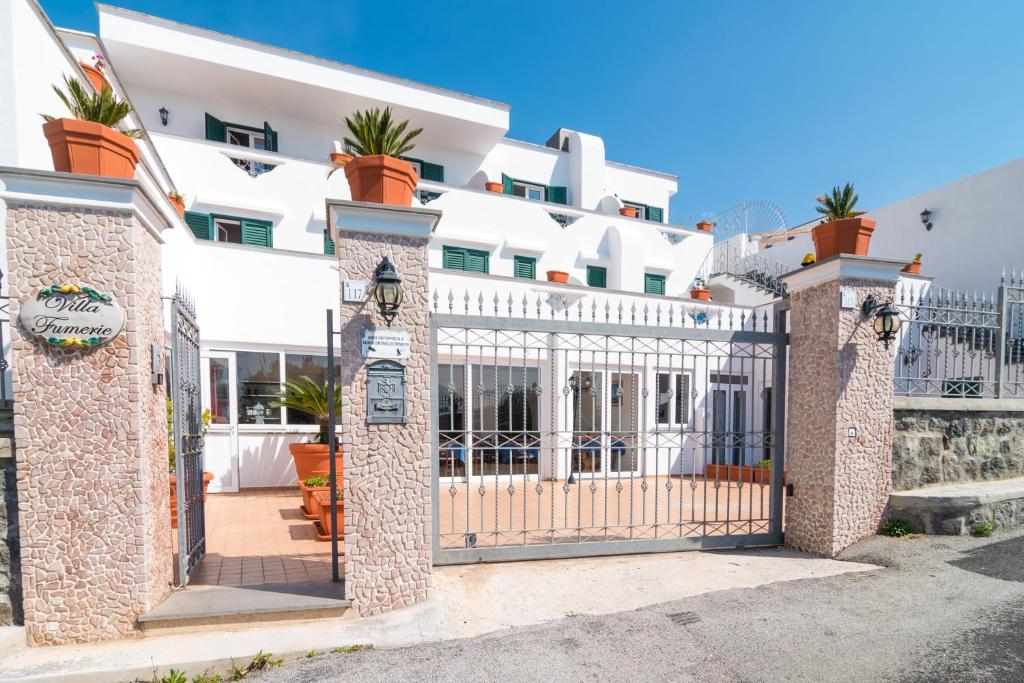 a gate in front of a white building at Hotel Villa Fumerie in Ischia