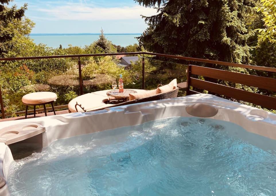 een hot tub op een balkon met uitzicht op de oceaan bij Kis Pele nyaraló in Balatongyörök