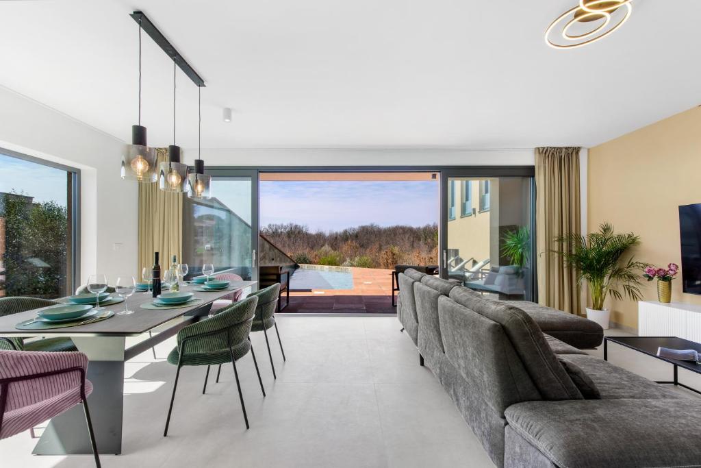 Un comedor y una sala de estar con mesa y sillas. en Villa Ana, en Novigrad Istria