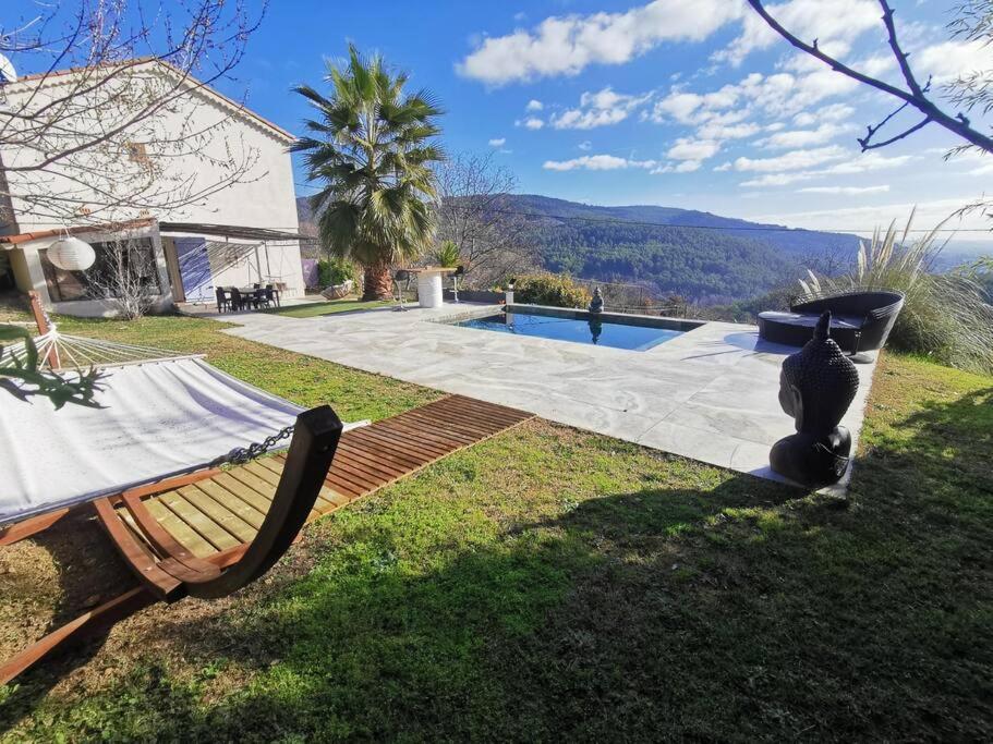 a yard with a bench and a swimming pool at Villa avec vue entre Mer et Lac in Ampus