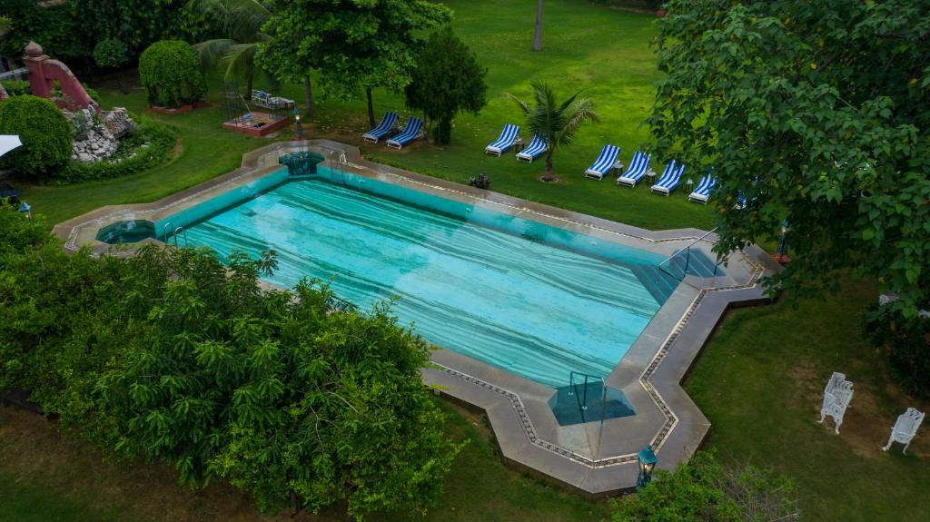 an overhead view of a swimming pool with chairs and trees at Hotel Narain Niwas Palace in Jaipur