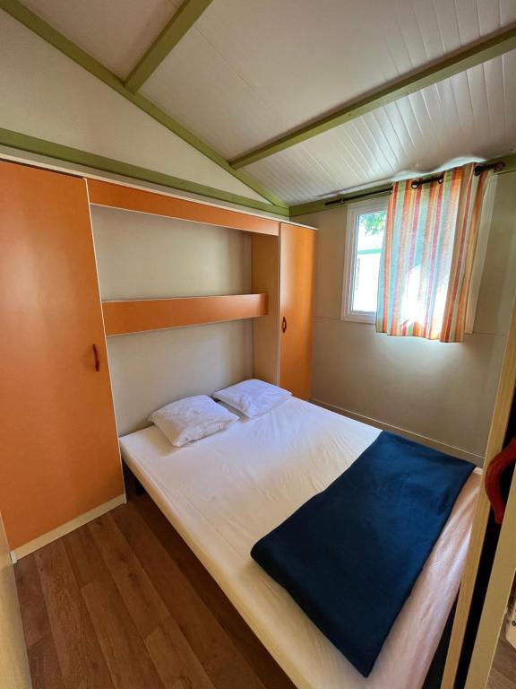 a small bedroom with a bed in a house at Le Camping de la Plage in Aregno