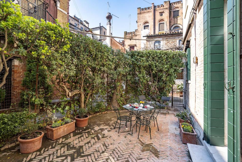 eine Terrasse mit einem Tisch, Stühlen und Pflanzen in der Unterkunft Ca' Margherita Secret Garden in Venedig