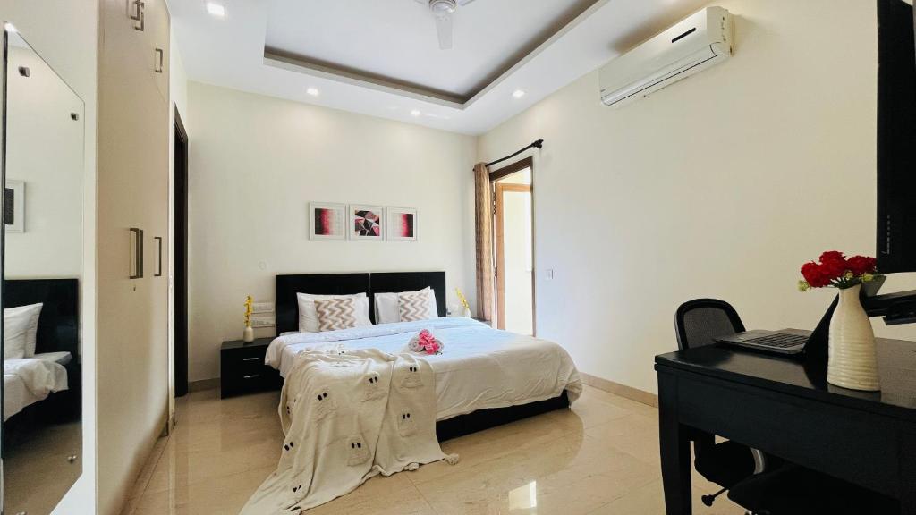 a white bedroom with a bed and a piano at BluO Studio DLF CyberCity - Kitchen, Balcony, Lift in Gurgaon