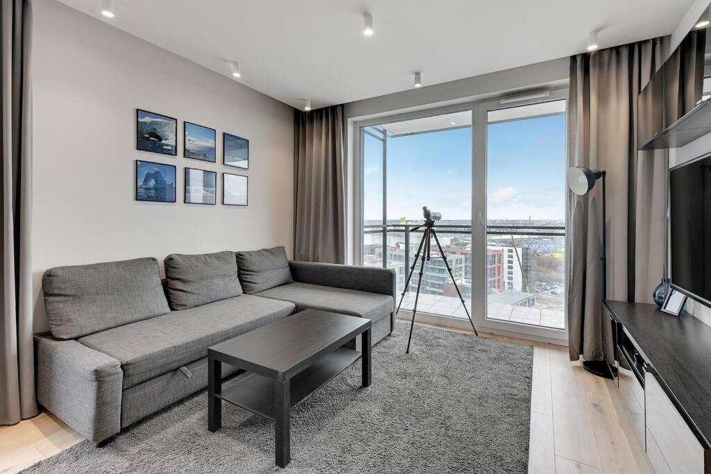 a living room with a couch and a large window at Viewpoint - Bastion Wałowa by Grand Apartments in Gdańsk