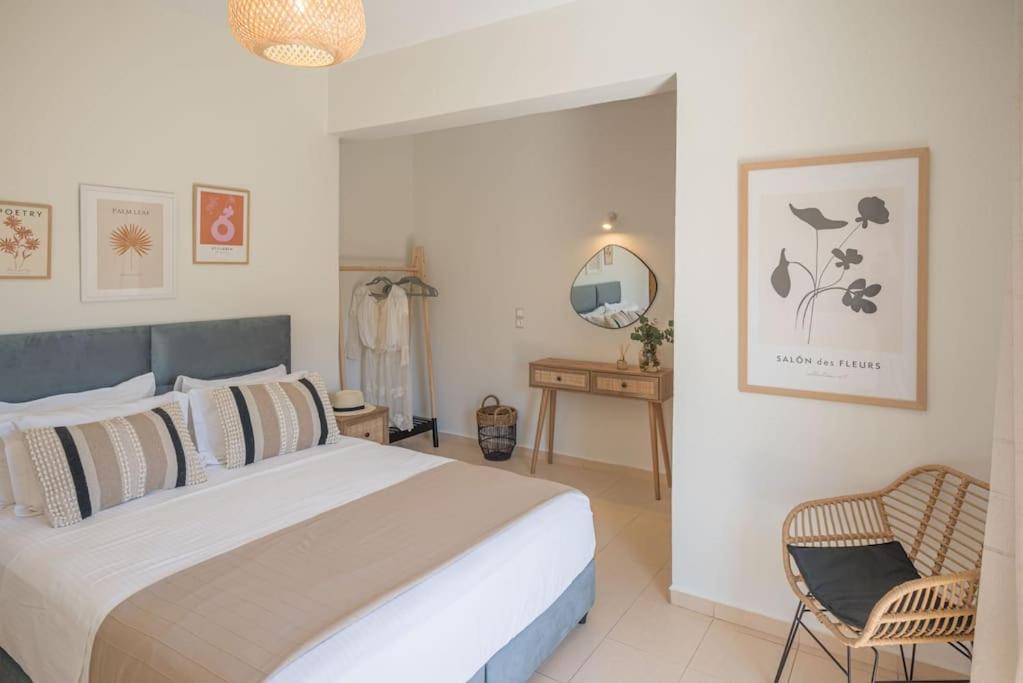 een slaapkamer met een groot bed en een stoel bij Summer Blue Apartments Chania in Chania