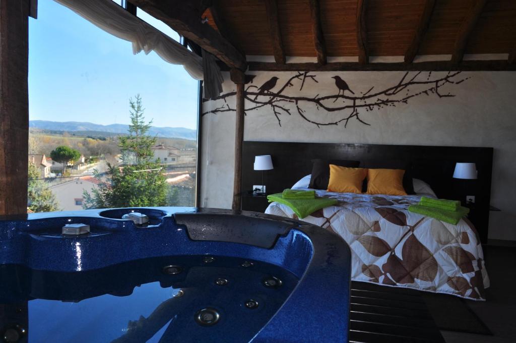 1 dormitorio con bañera azul y 1 cama en Suite rural con jacuzzi, en Cabañas de Polendos