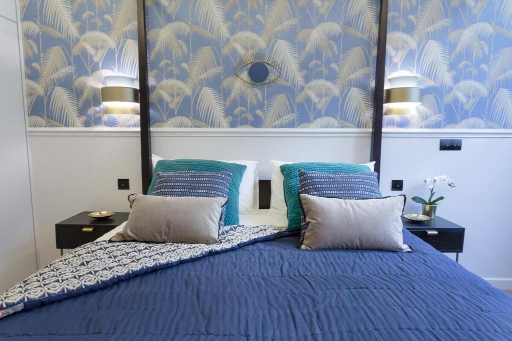 a bedroom with a blue bed with two pillows at Le Café des Invalides in Paris