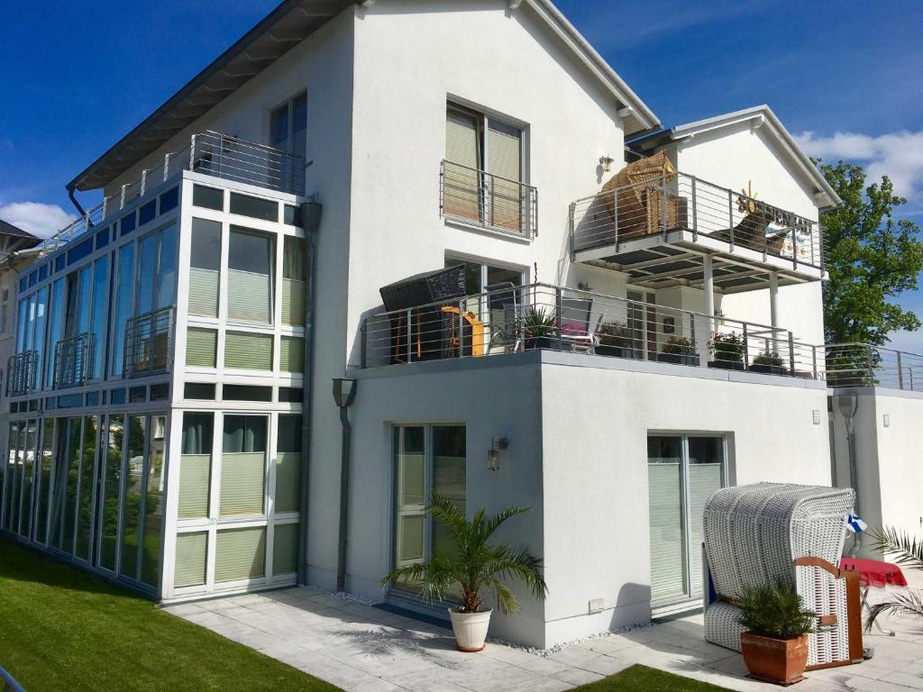 a white house with a balcony on top of it at Appartement Nr 10 im Sonnenbad in Sassnitz