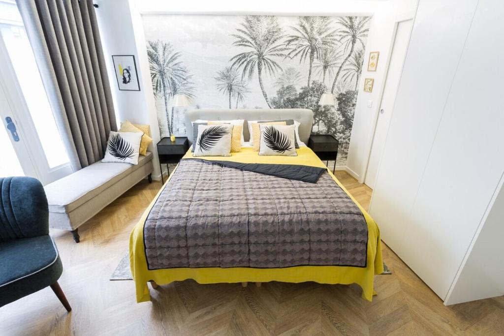 een slaapkamer met een groot bed en een bank bij La Boutique du Sentier in Parijs