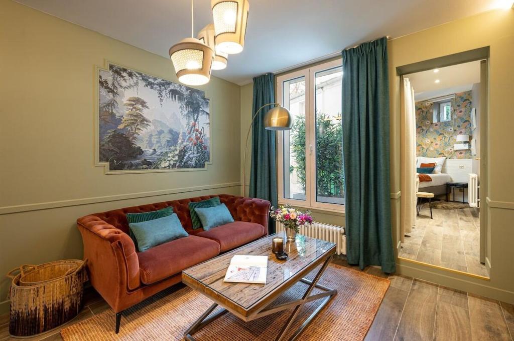 ein Wohnzimmer mit einem Sofa und einem Tisch in der Unterkunft My Boudoir in Paris