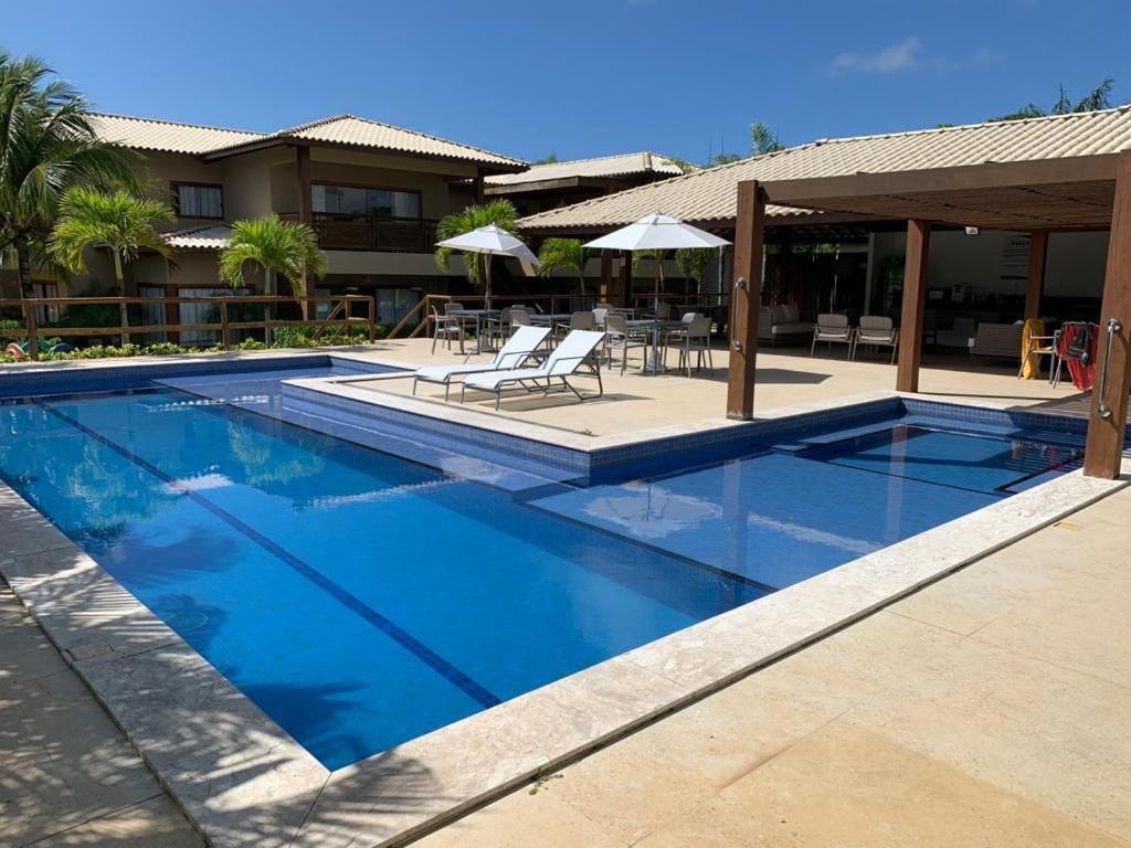 uma piscina com água azul num resort em Reserva Eco Itacimirim em Camaçari