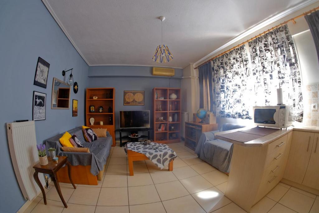 a living room with a couch and a tv at Adorable Apartment in the center in Volos