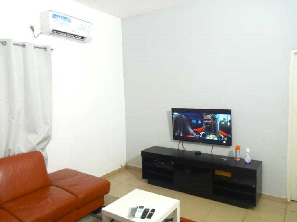 a living room with a couch and a flat screen tv at HEBERTOGO TOKOIN CASABLANCA in Lomé