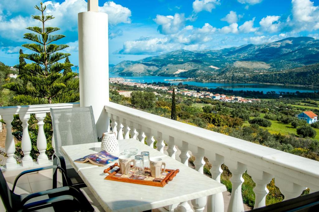 een balkon met een tafel en uitzicht op de stad bij Nikos Apartments Spacious and Panoramic in Argostoli