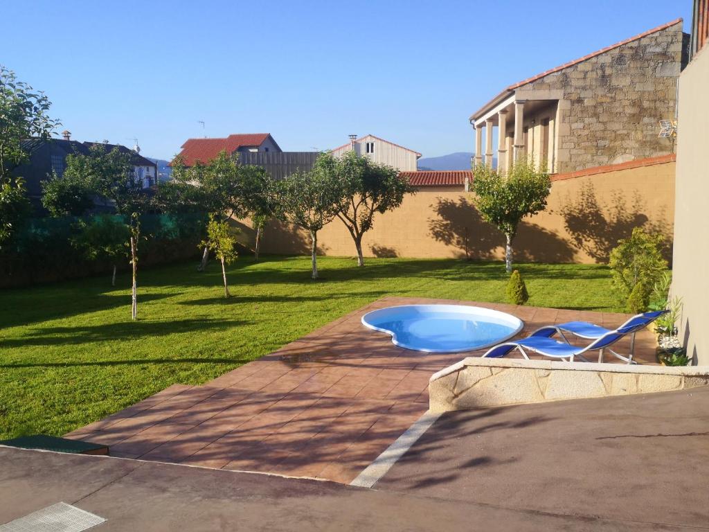 a swimming pool with a blue tub in a yard at Charming House in Esteiro with Garden and Terraces in Esteiro