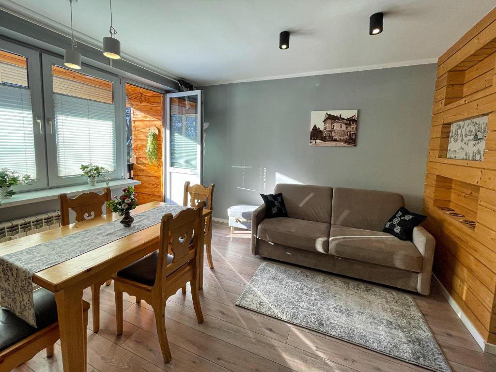 uma sala de estar com um sofá e uma mesa em Apartament Tytusowy Potok em Zakopane