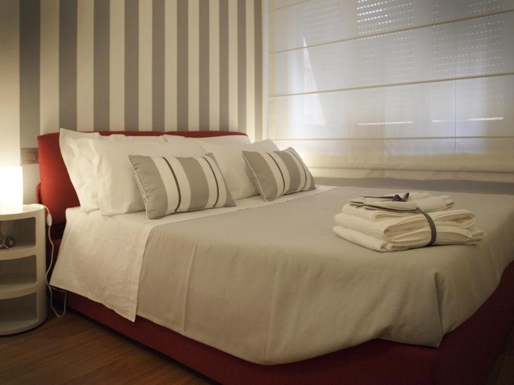 a bedroom with a bed with white sheets and pillows at La Cittadella in La Spezia