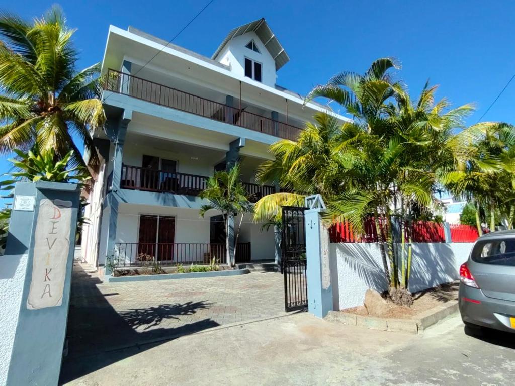 een huis met palmbomen ervoor bij 2 bedrooms apartement with furnished terrace and wifi at Trou aux Biches 1 km away from the beach in Trou aux Biches