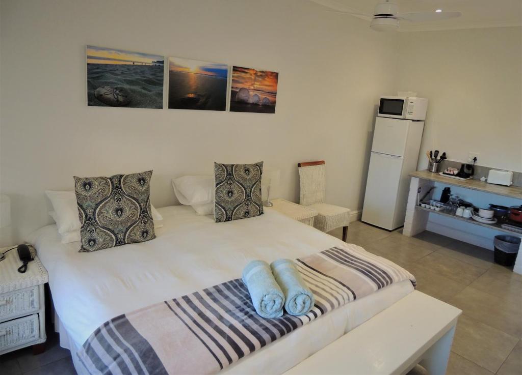 a bedroom with a large white bed with two pillows at Sand Dollar @ The Dunes in Plettenberg Bay