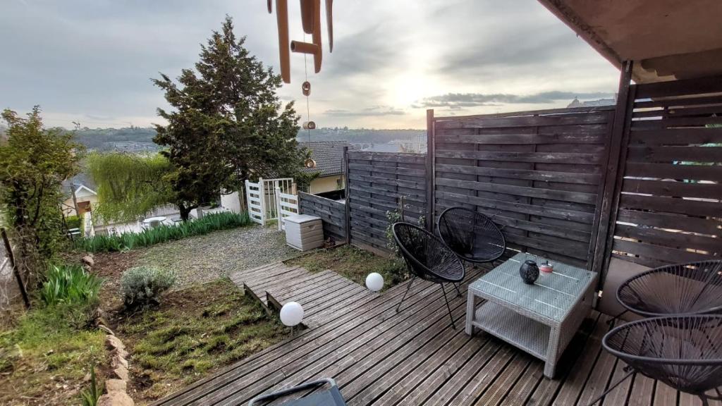 a patio with a table and chairs on a deck at Appartement Duplex avec jardin in Rodez