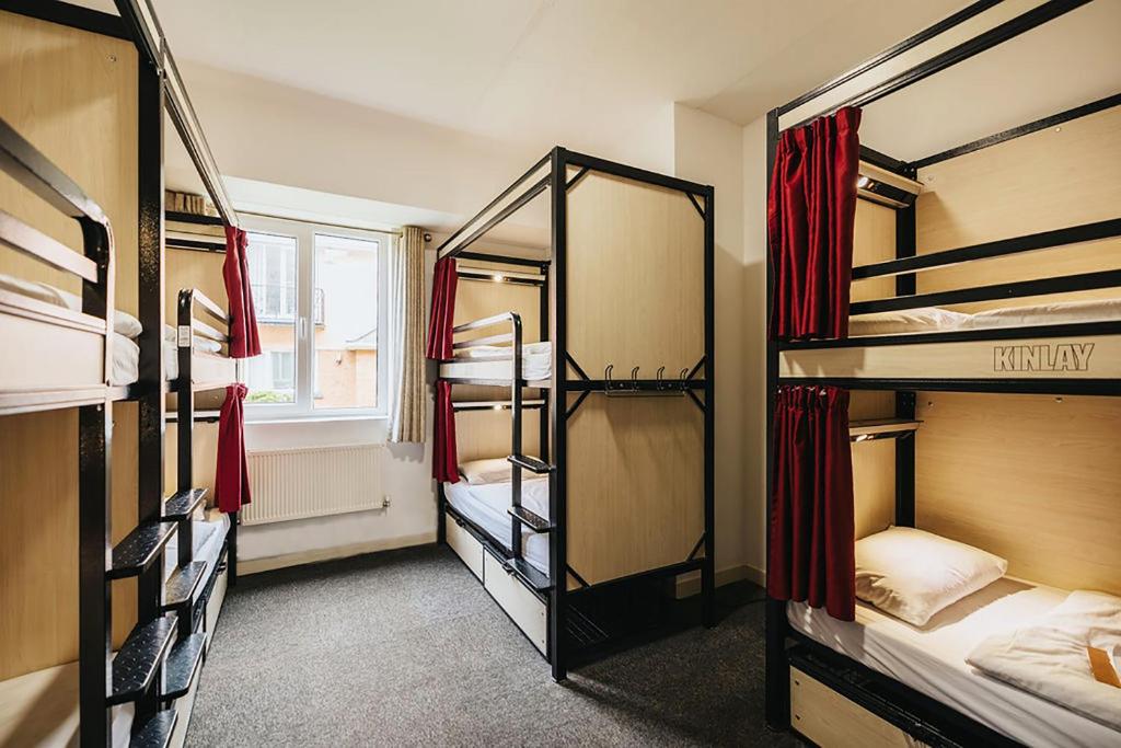 a room with three bunk beds and a window at Kinlay Hostel Eyre Square in Galway