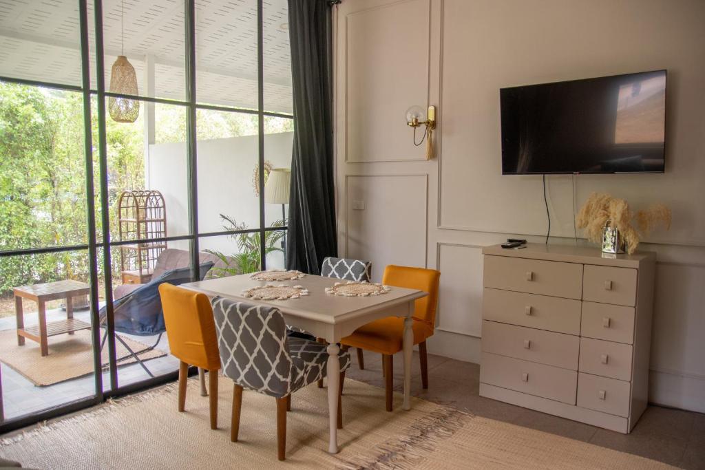 ein Esszimmer mit einem Tisch, Stühlen und einem TV in der Unterkunft Spacious fancy house/centrally located in Hinkong