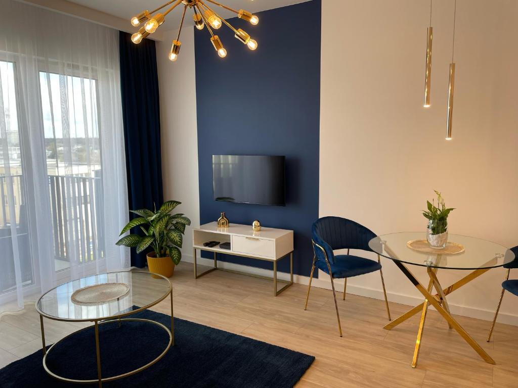 Una sala de estar con una mesa y un televisor. en Apartament przy Marsa, en Varsovia