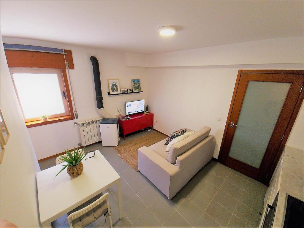 ein Wohnzimmer mit einem Sofa und einem Tisch in der Unterkunft Charming Pedra in Braga