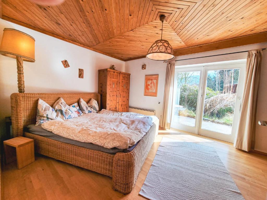 a bedroom with a bed and a large window at Ruhige Wohnung mit schönem Eigengarten in Seeboden am Millstättersee in Seeboden