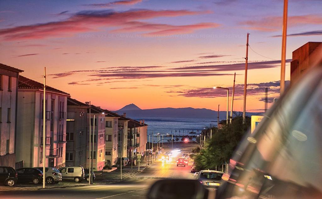 a city street at sunset with cars parked on the street at Charme Apartment Center in Angra do Heroísmo