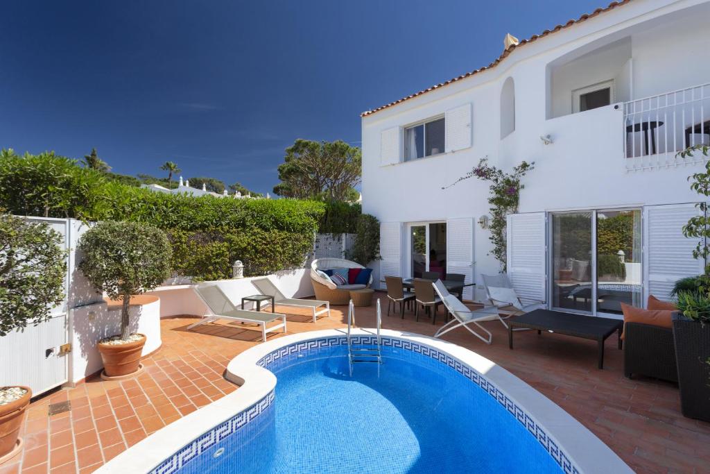 a villa with a swimming pool and a house at Vila Senna in Vale do Lobo