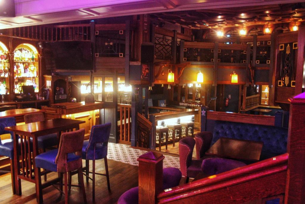 un bar con sedie blu e tavoli in una stanza di Pv Fallons a Longford