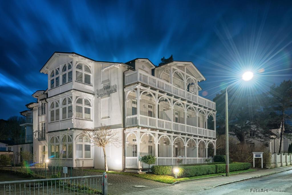 a white building at night with a street light at Villa Jugendglück by Rujana in Binz