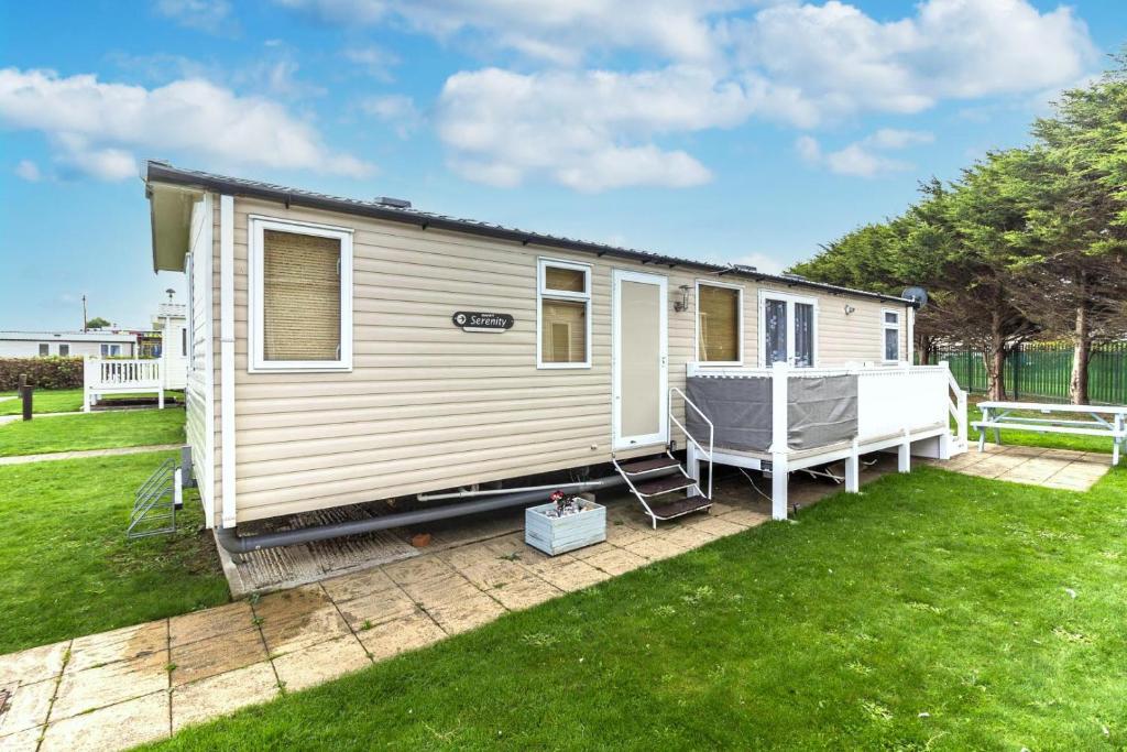 une petite maison assise sur une pelouse dans une cour dans l'établissement Brilliant 8 Berth Caravan At Haven Caister Holiday Park In Norfolk Ref 30024d, à Great Yarmouth