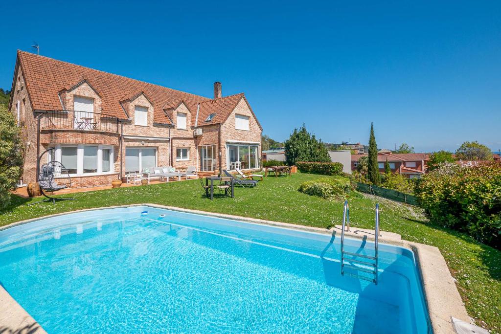 a house with a swimming pool in front of a yard at Bista Eder Hotel & Lodge in Hondarribia