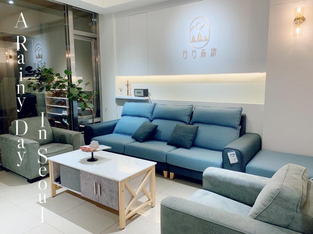 uma sala de estar com sofás azuis e uma mesa de centro em Day and Day Hotel No1 em Tianwei