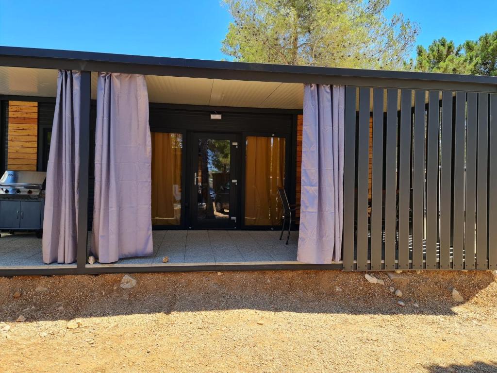 a screened in porch with purple curtains on it at Kamp Dalmacija in Privlaka