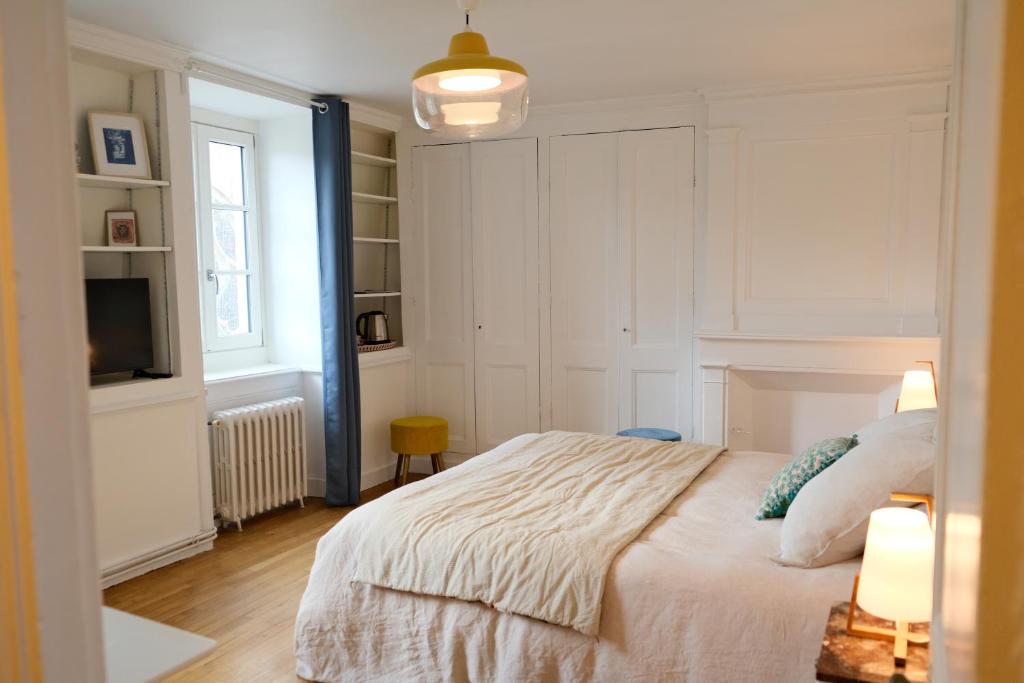 a bedroom with a large bed and a television at Contes à Rebours - Chambres d'hôtes in Morlaix