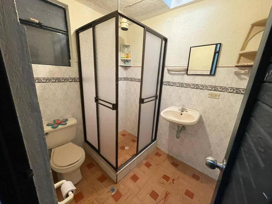 a small bathroom with a toilet and a sink at Casa con piscina para descanso in Chachagüí