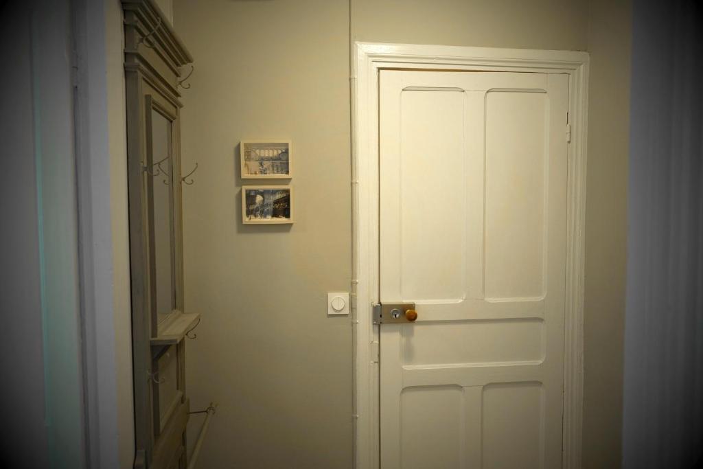 a white door in a hallway with a picture on the wall at Contes à Rebours - Chambres d&#39;hôtes in Morlaix