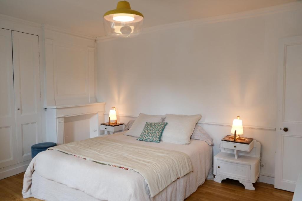 a bedroom with a bed with two lamps on two tables at Contes à Rebours - Chambres d&#39;hôtes in Morlaix