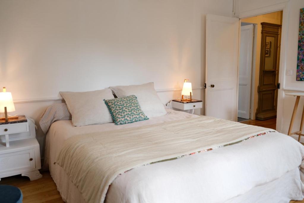 a bedroom with a large white bed with two lamps at Contes à Rebours - Chambres d&#39;hôtes in Morlaix